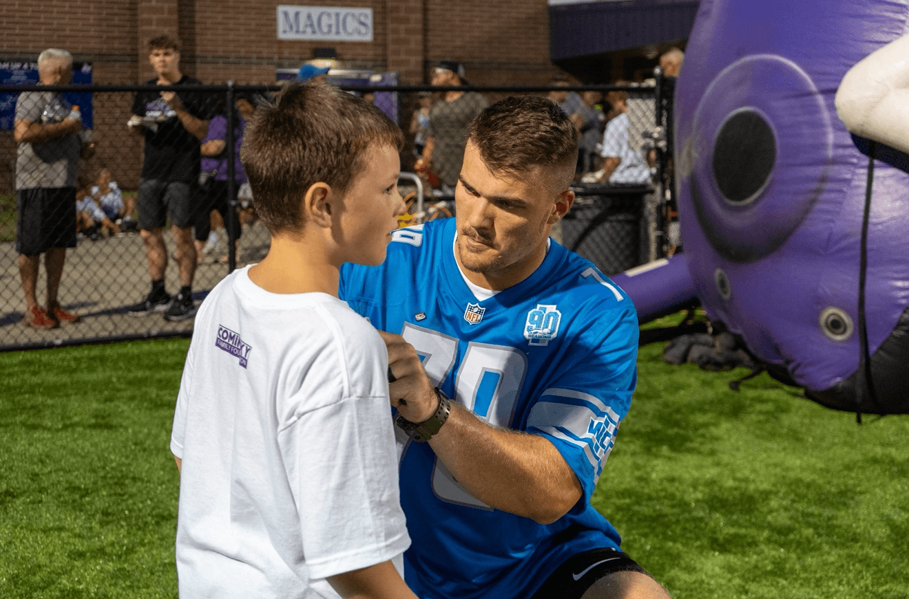 John Cominsky signing a young participant's shirt